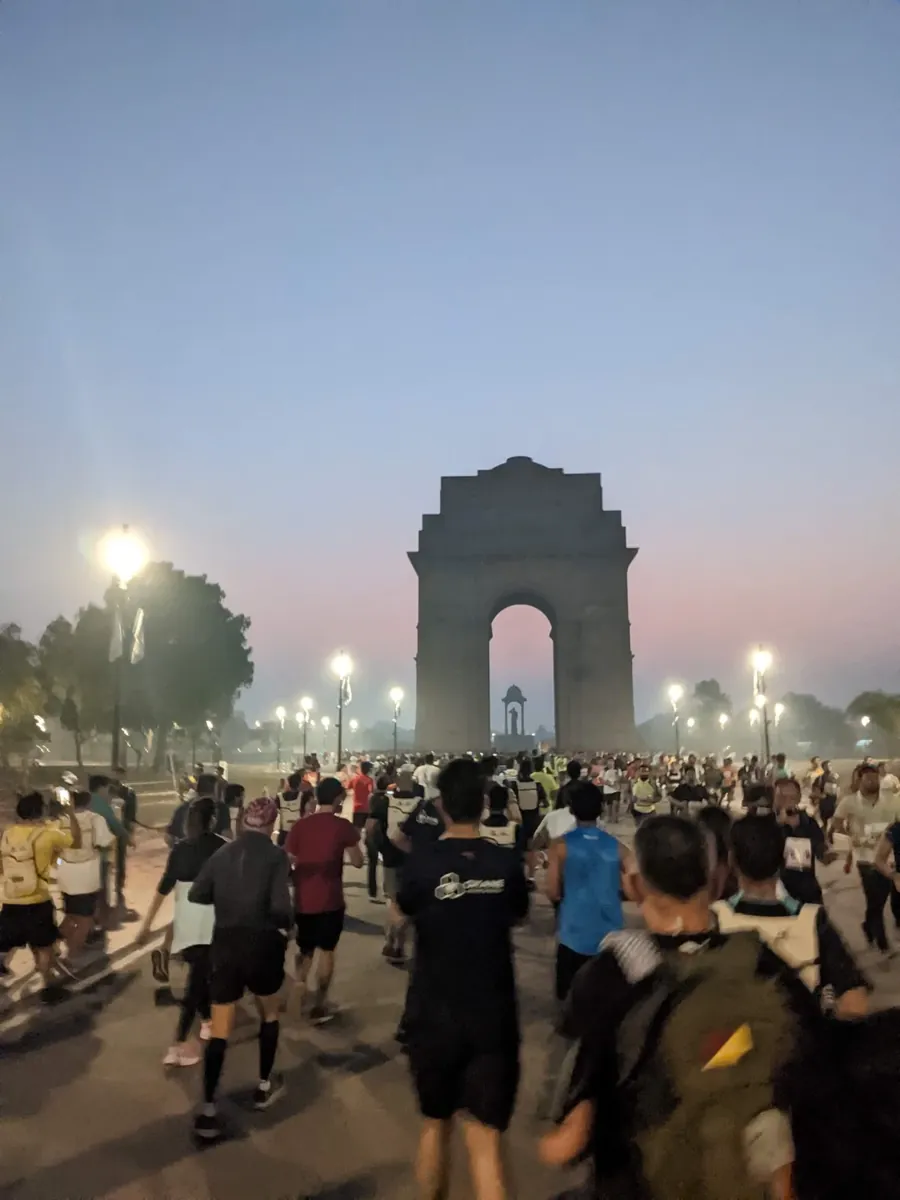 Runners heading towards India Gate at dawn during the Delhi Half Marathon 10K